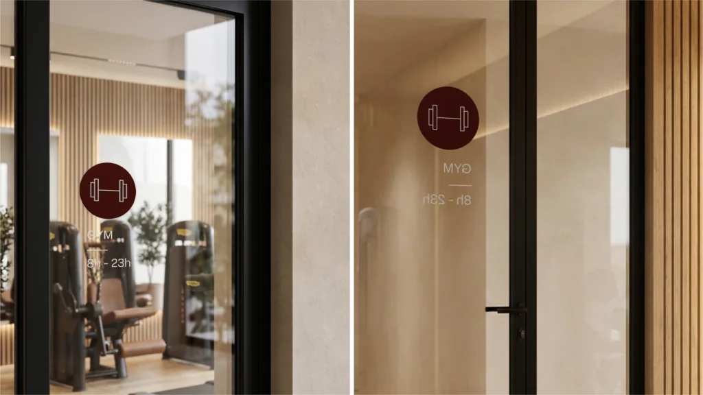 Pictogramme du gym sur des portes vitrées, avec les heures d'ouverture