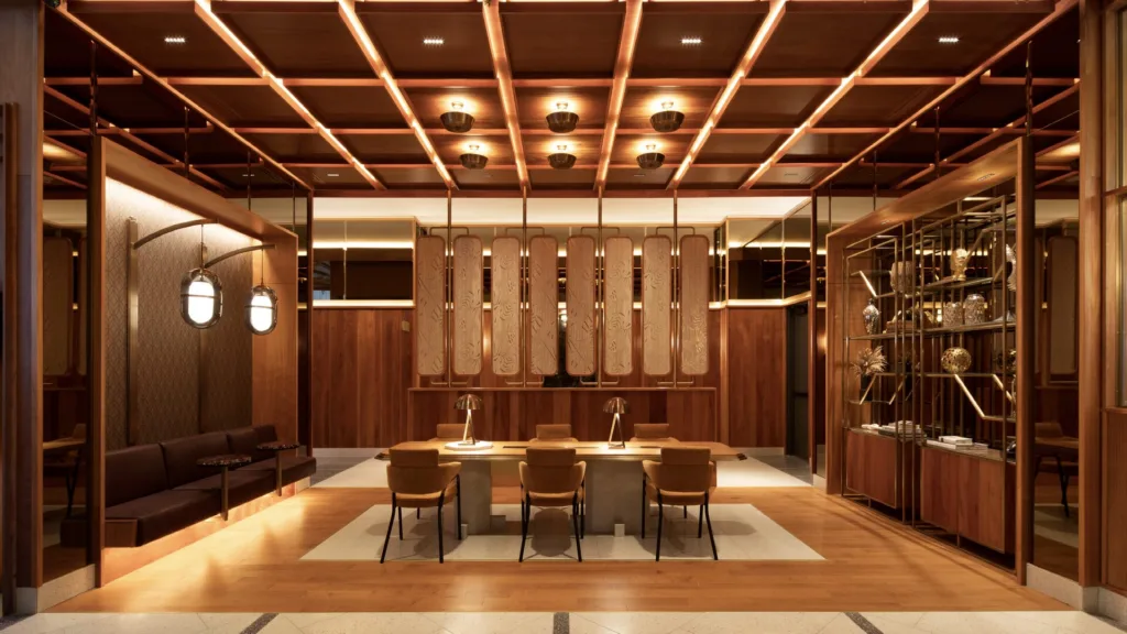 Salle de réunion boisée avec grande table et plafond à caissons