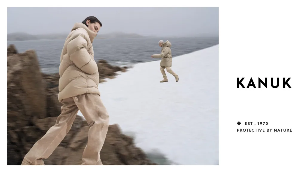 Publicité KANUK : homme en manteau sur des rochers enneigés