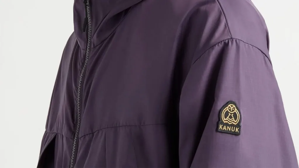 Écusson au harfang cousu sur la manche d'un manteau violet