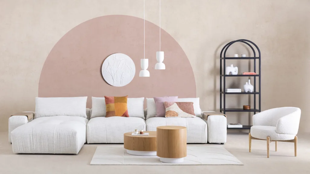 Salon blanc et rose avec canapé modulaire et grand demi-cercle au mur
