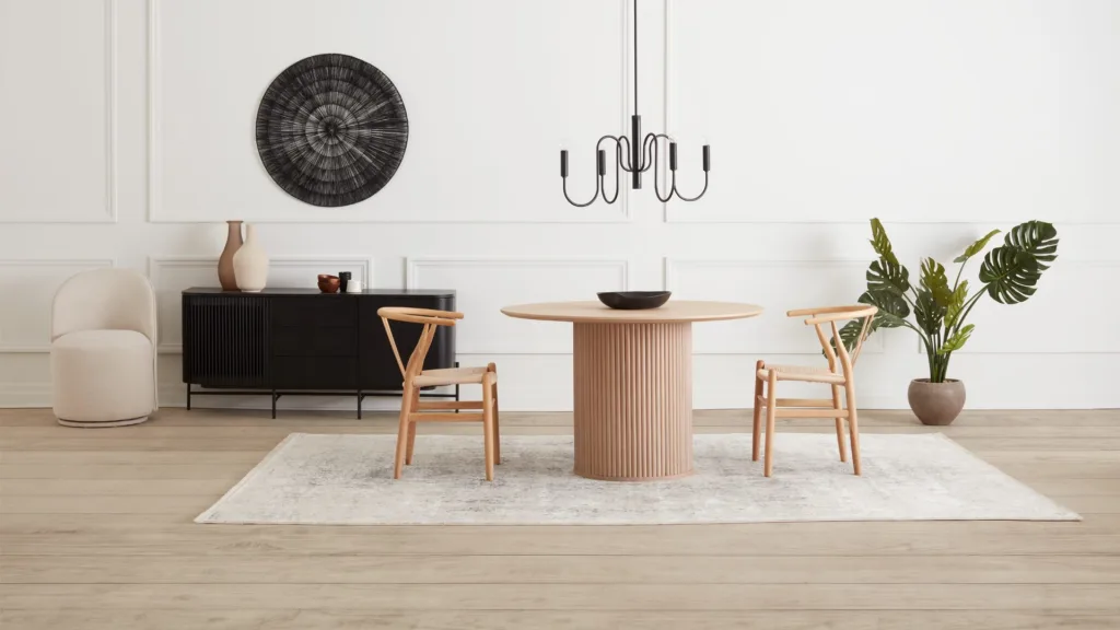 Salle à manger avec table ronde en bois, chaises en bois et buffet noir
