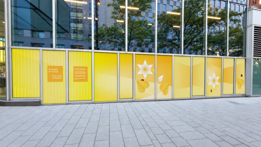 Façade vitrée habillée de panneaux jaunes fleuris, vue de la rue